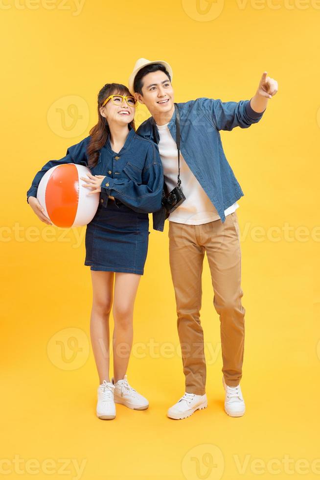Happy Asian couple in summer beach casual clothes studio shot isolated on yellow banner background with copy space photo