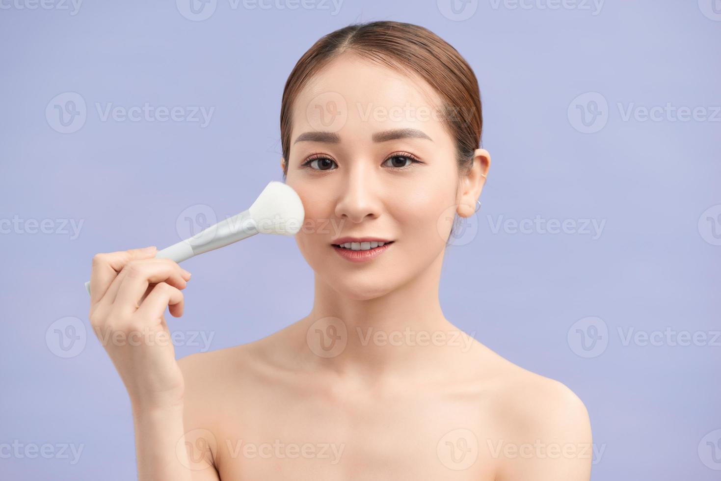 Beauty Face. Portrait Of Beautiful Smiling Girl Applying Loose Blush With Cosmetic Brush. photo