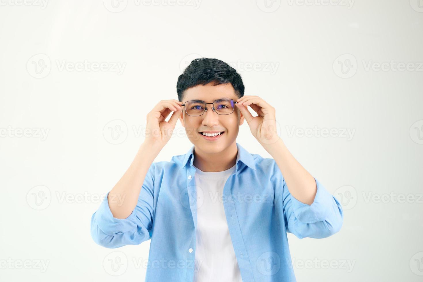 Closeup of friendly guy wearing eyeglasses. Young asian man adjusting glasses and staring at camera through lens. Vision and eye care concept photo