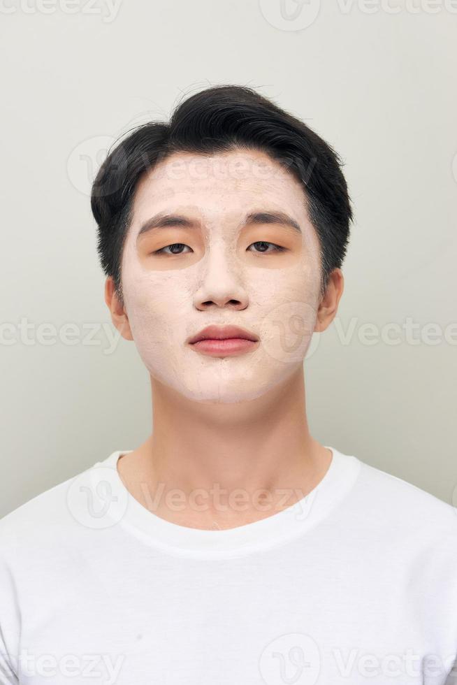 relaxing man with a mud mask on this face photo