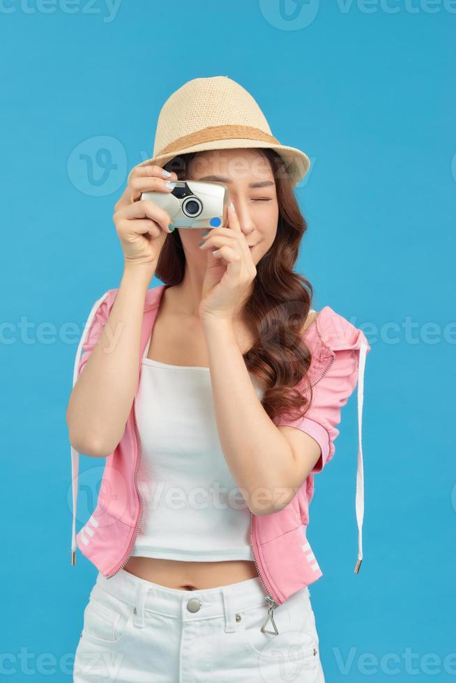 Smiling woman with travel case holding photo camera. Traveler girl isolated portrait.