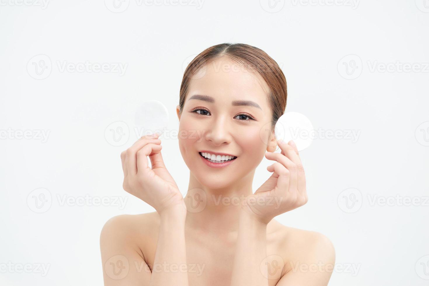Smiling woman holds cotton pads on white background. Skin care concept. photo