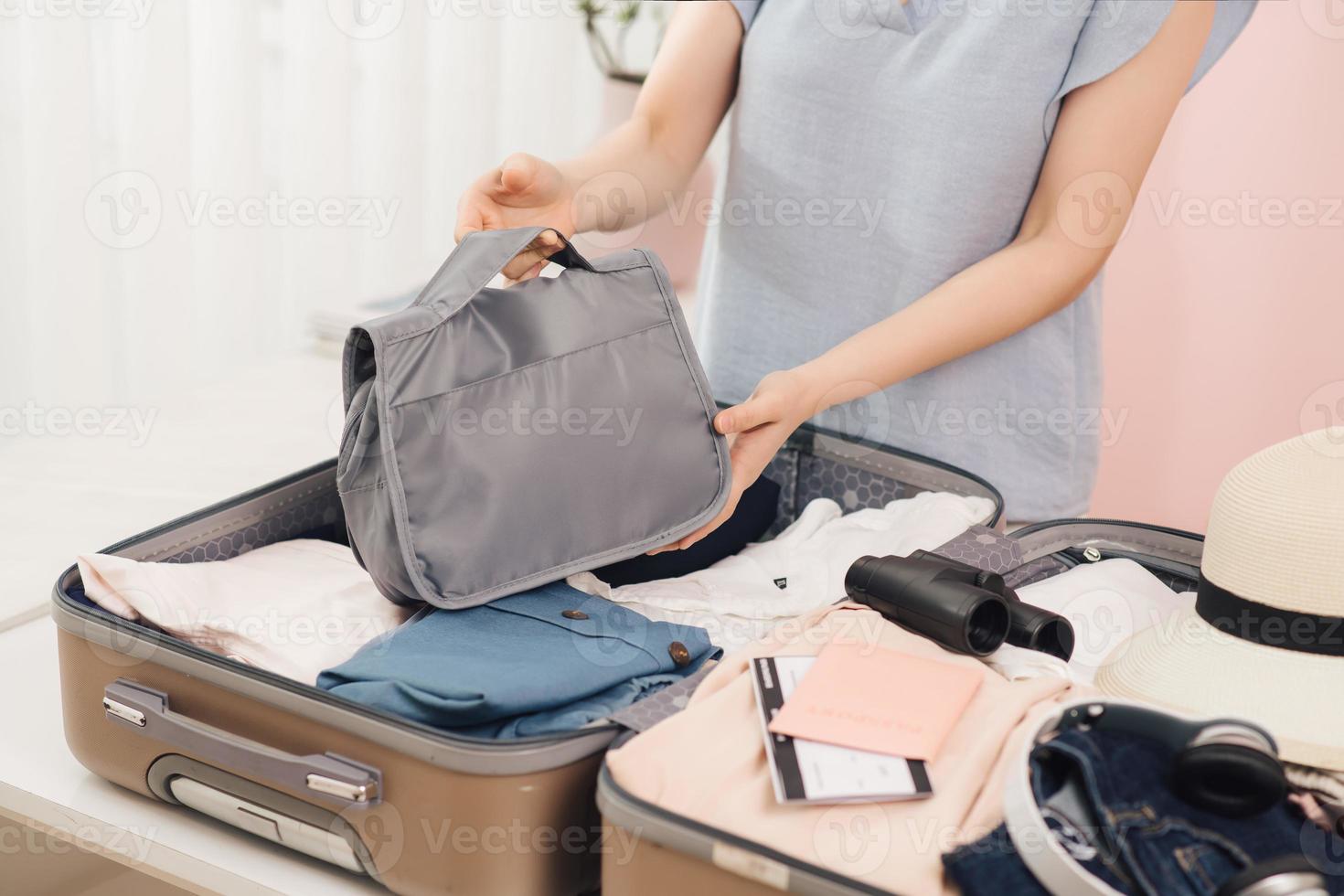 Cheerful Female Packing Suitcase And Getting Ready For Traveling photo