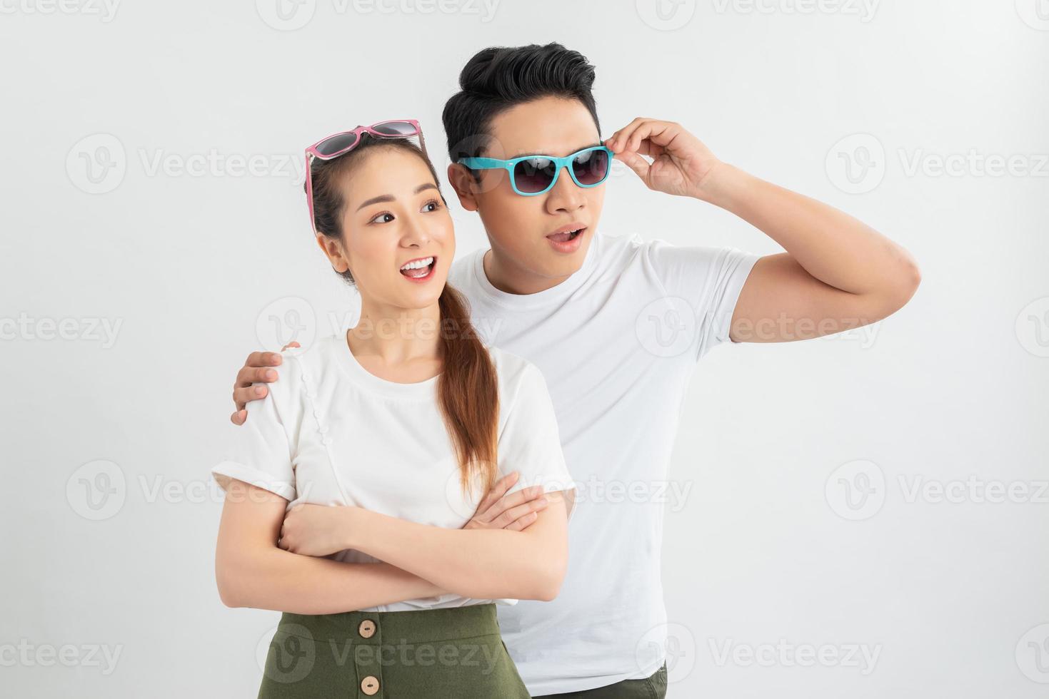 Surprised young couple looking at camera. Front view of excited young man and woman standing together and looking at camera on white background. Emotion concept photo