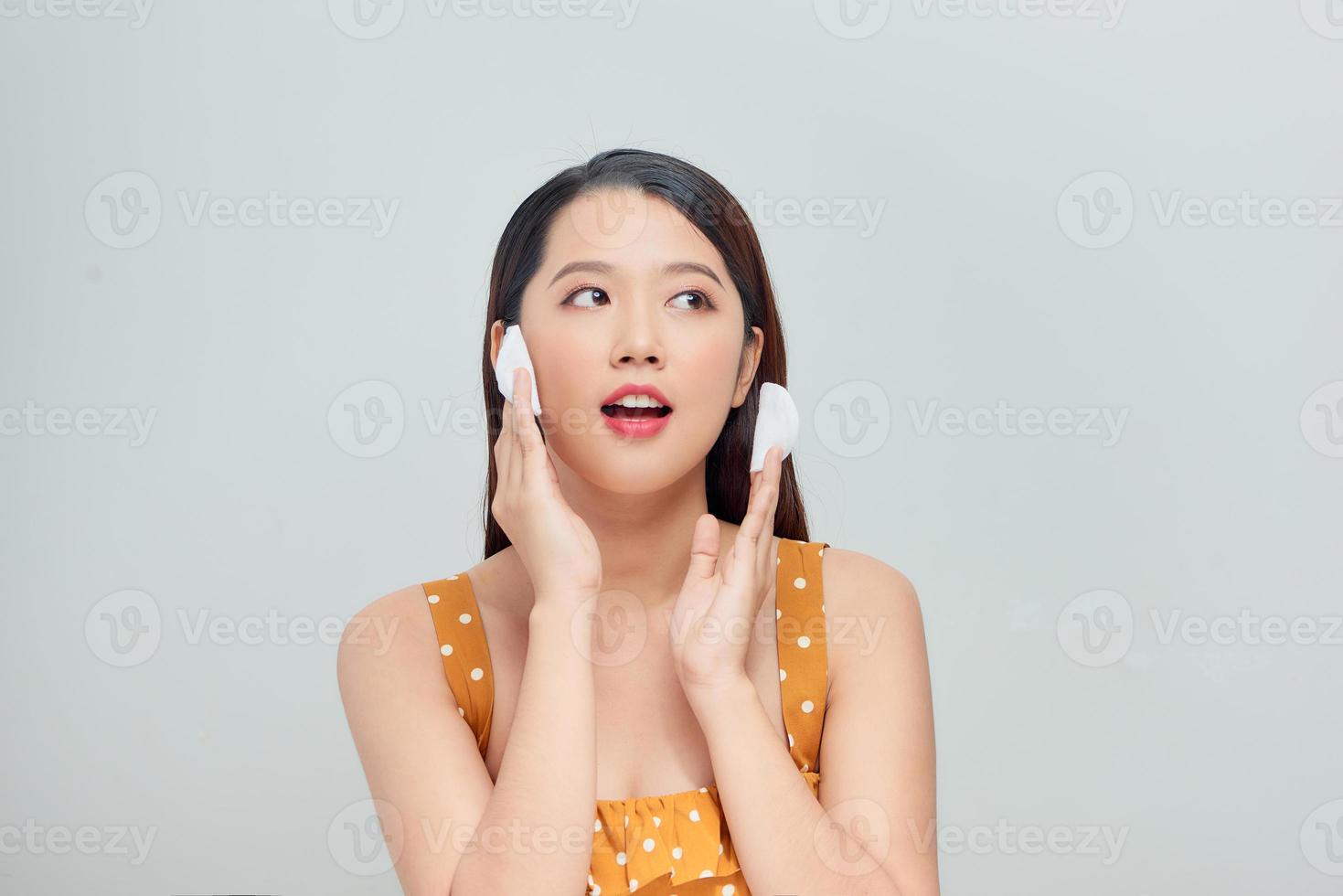 Woman removing makeup with cleansing pad photo