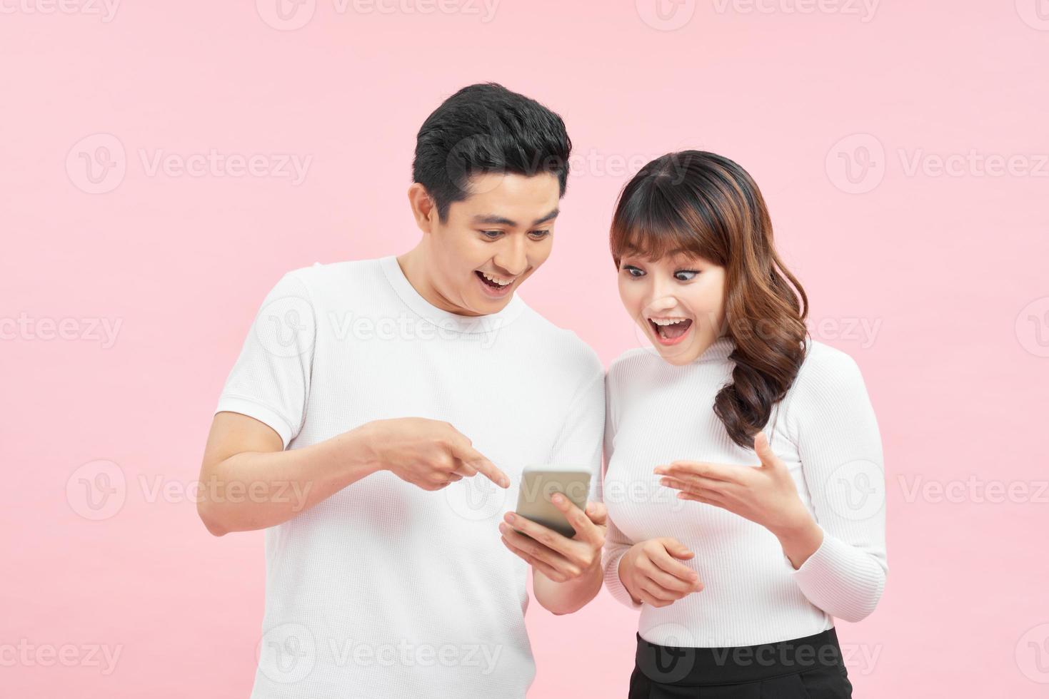 Portrait of Asian couple shocked or surprised to see something on smart phone, happy expression winning gesture photo