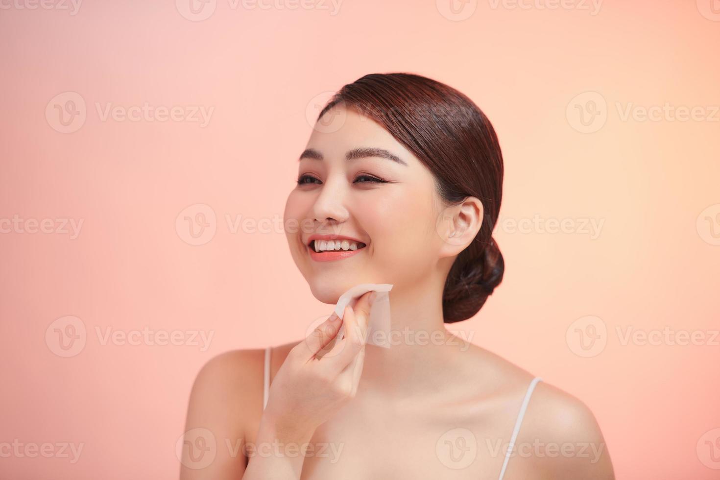 Closeup Portrait Of Beautiful Healthy Girl With Nude Makeup Cleaning Perfect Soft Skin With Oil Absorbing Tissue Sheets photo