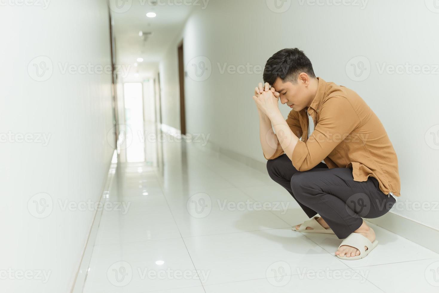 depressed man who lost faith sitting alone in a corridor photo