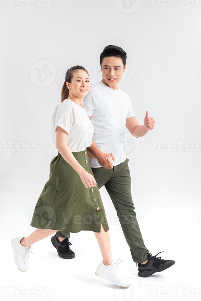 Young couple in casual clothes walking on white background 11135701