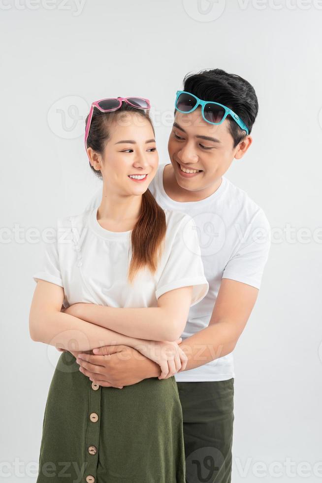 Young couple embracing and posing on white background photo