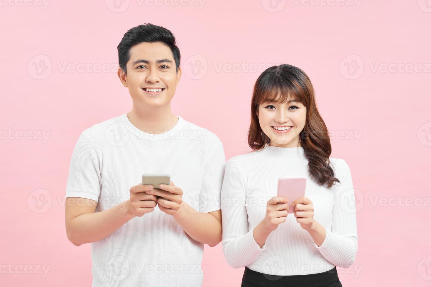 Image of asian man and woman using smartphones isolated over colorful background photo