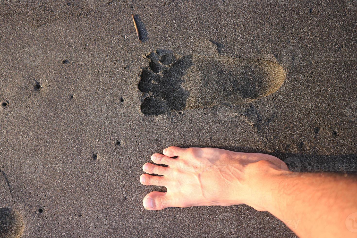 Human footprint on sand summer tropical beach at sunrise background with copyspace. photo