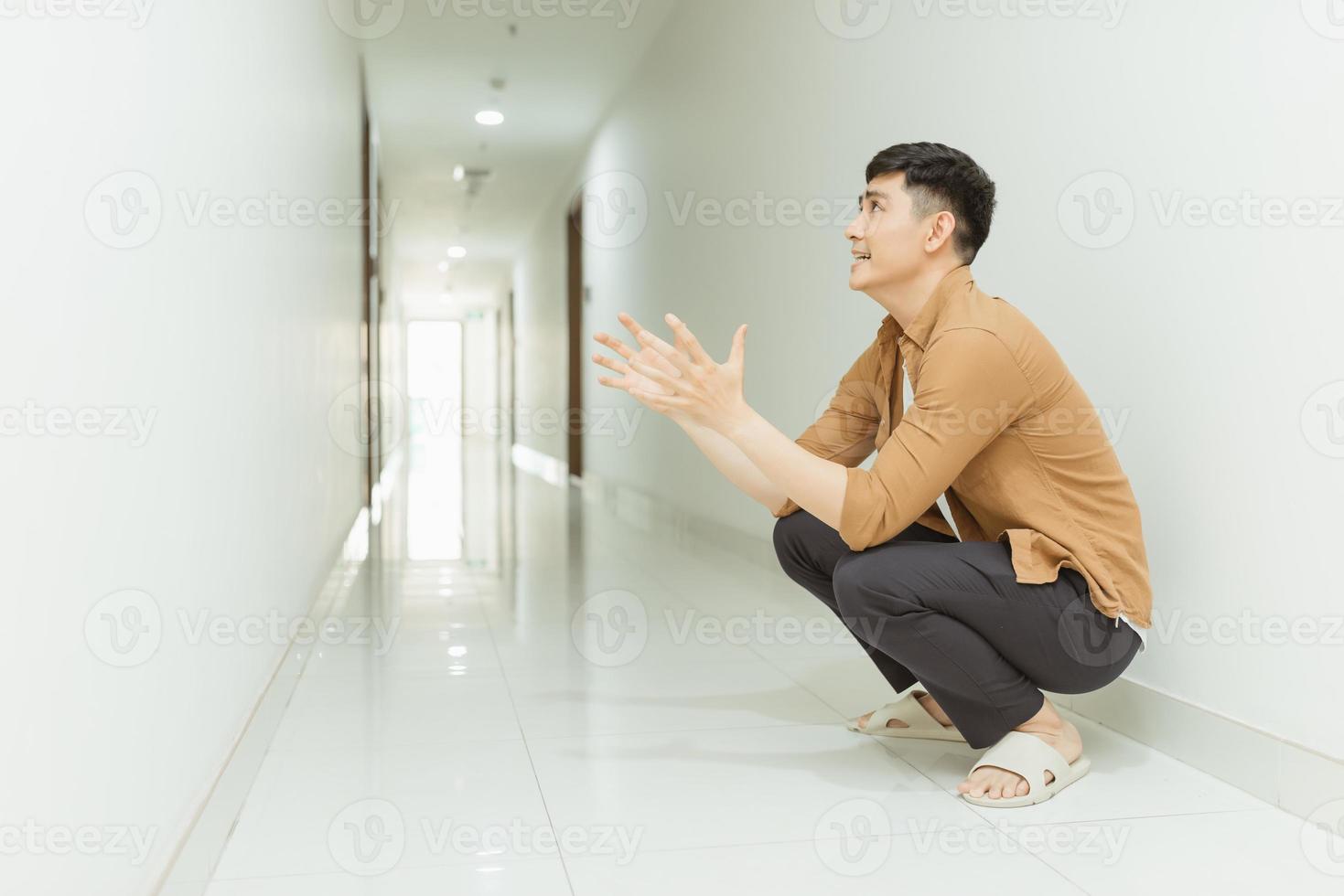 Depressed and sad woman sitting on the floor in a corridor. Low key. photo