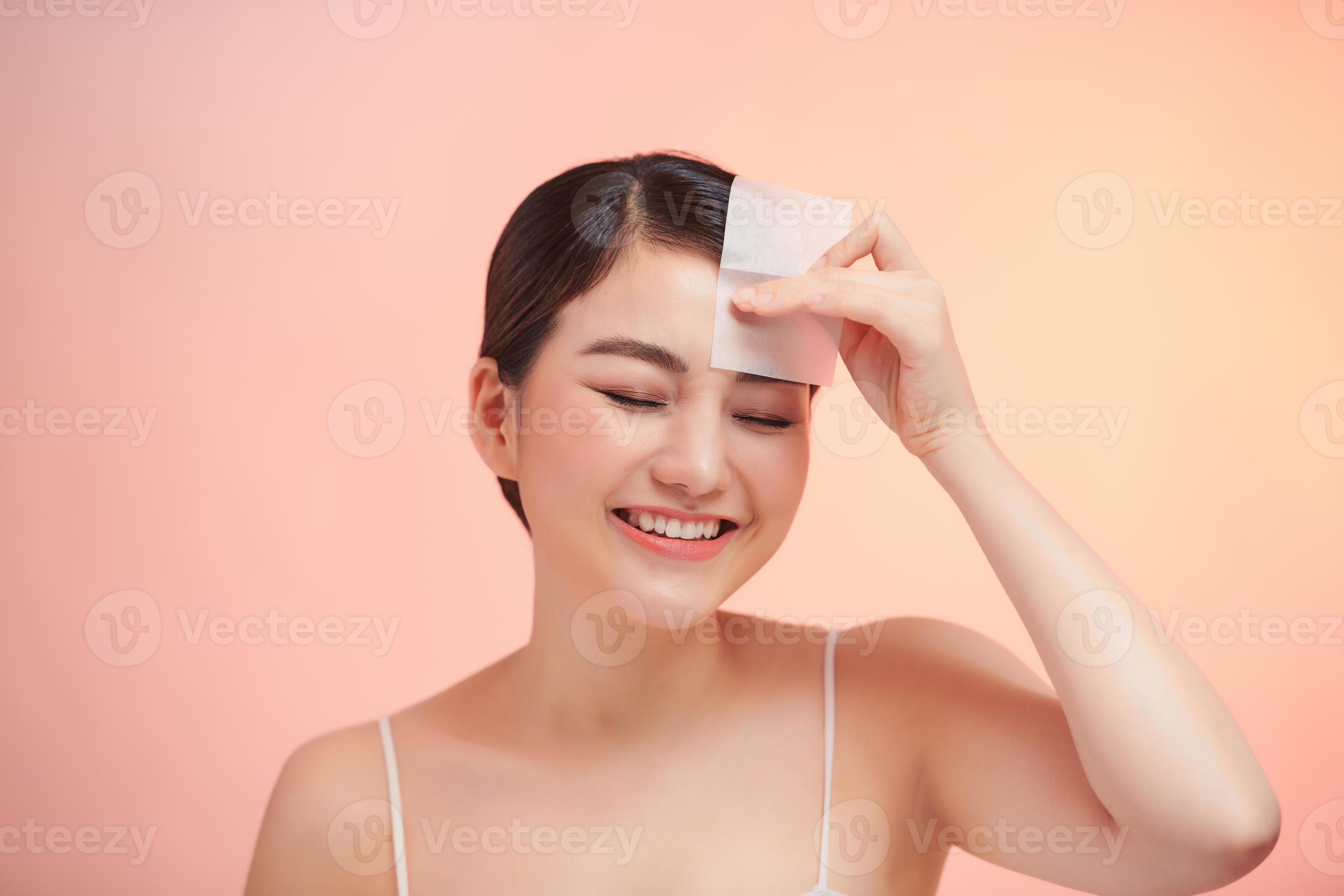 Woman Removing Oil From Face Using Blotting Papers. 11136975 Stock