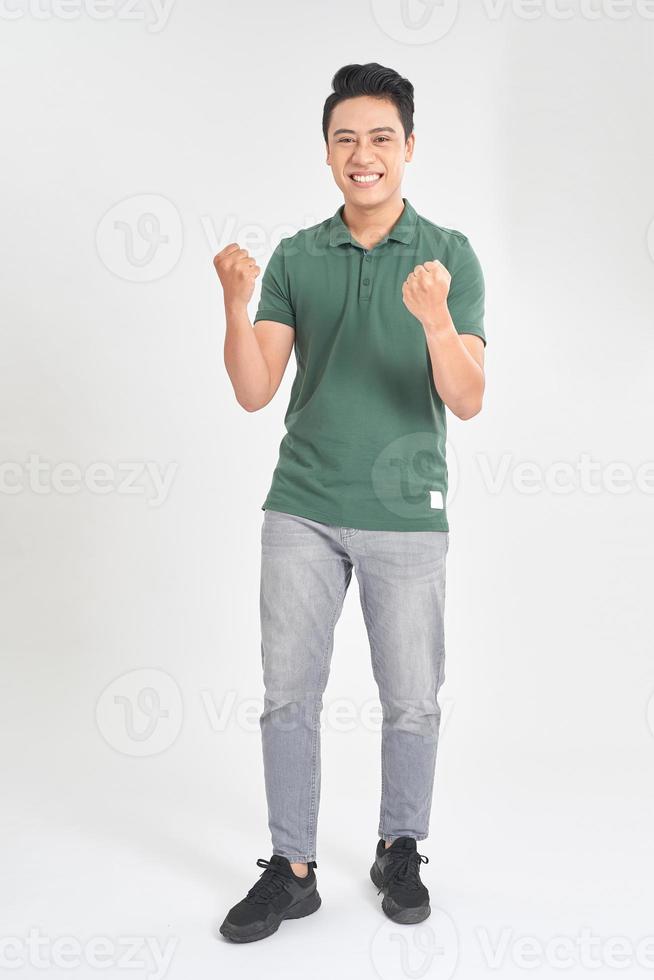 retrato de un joven emocionado celebrando el éxito con dos puños en el aire aislado en el fondo blanco foto