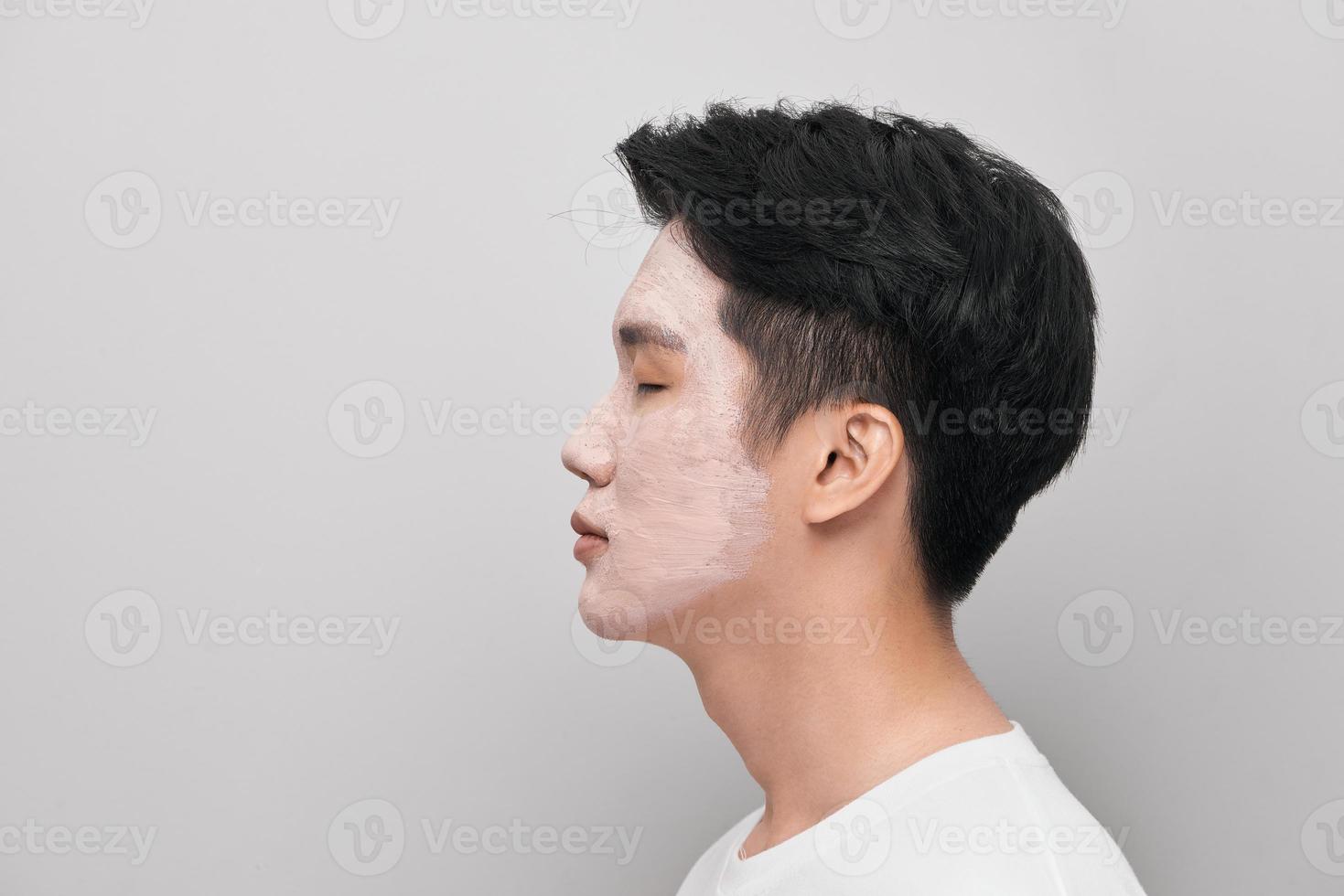 Handsome man with clay mask on his face against color background photo