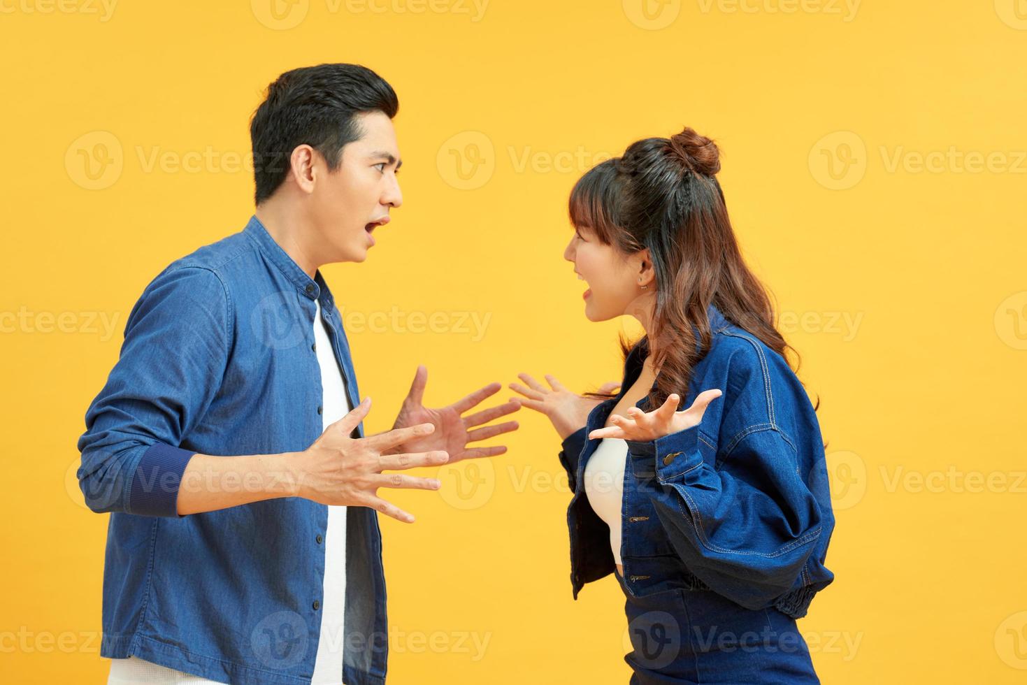 vProfile side view portrait of two attractive angry aggressive nervous people having fight anger blame isolated over vivid shine bright orange background. Negative emotions concept. photo