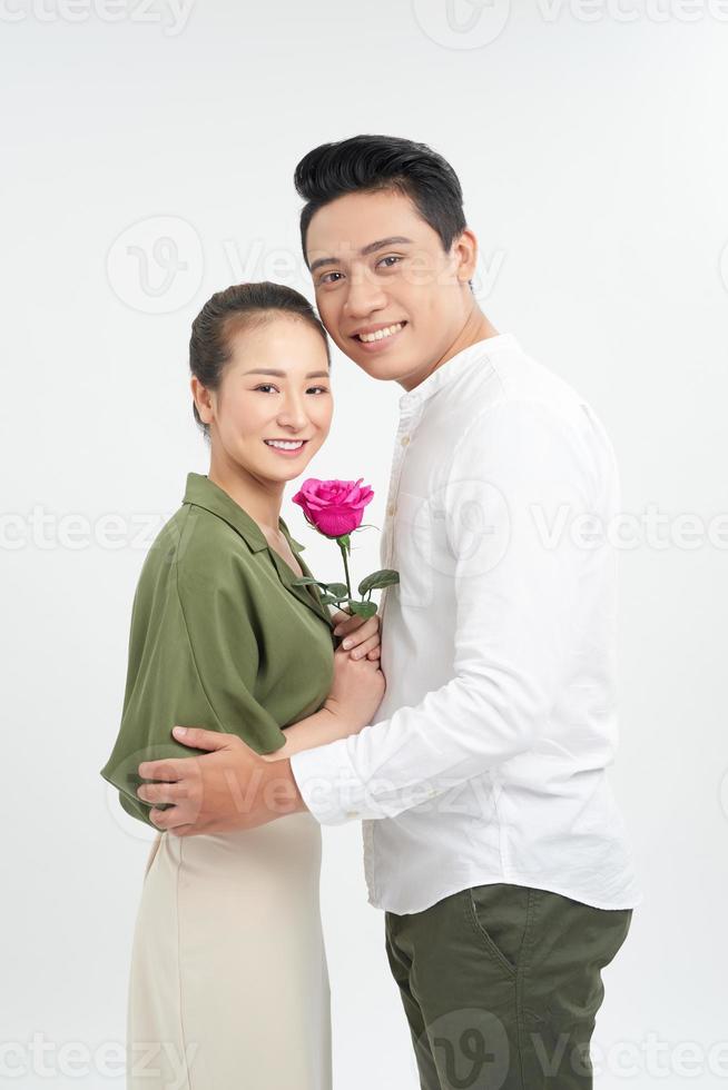 Young man giving rose to his girlfriend on white background photo