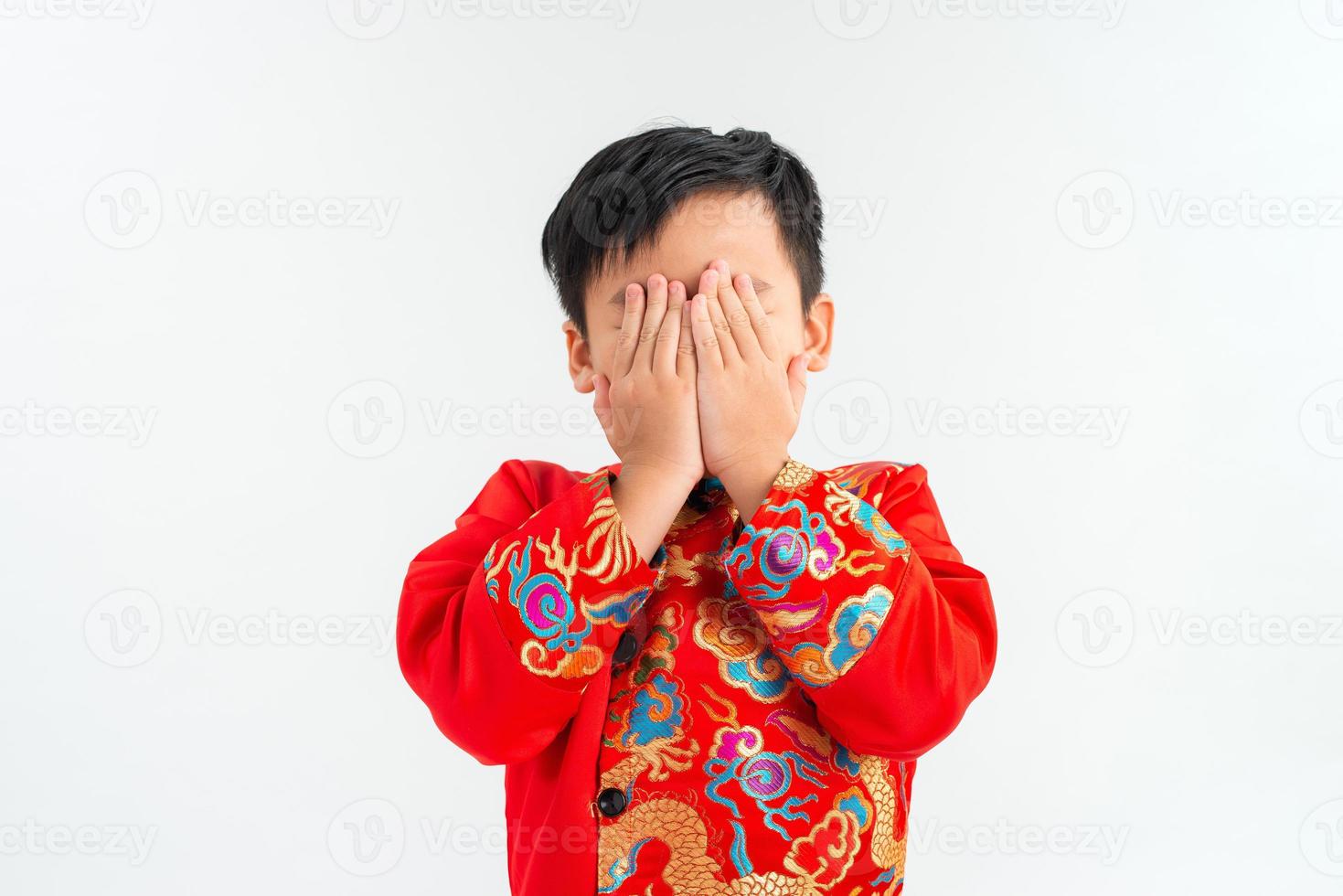 Copy space and Soft focus at little Asian boy covering his face with hands and playing hide and seek photo