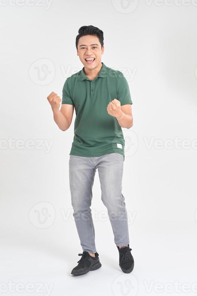 Portrait of a satisfied young man celebrating success isolated over white background photo