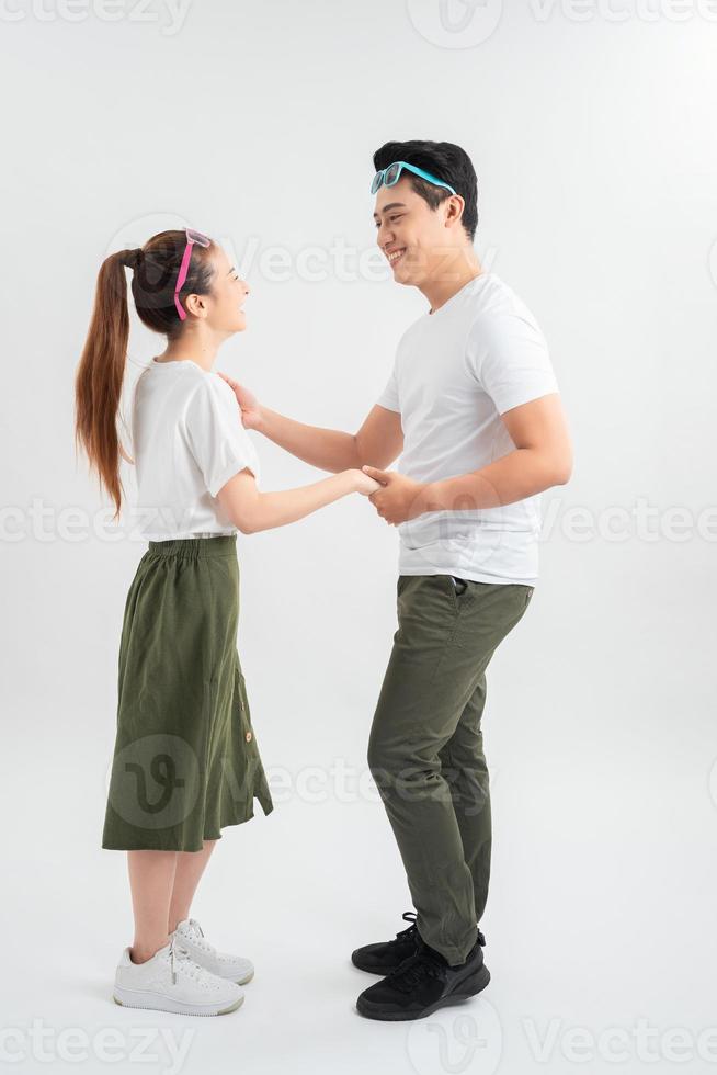 smiling young couple dancing and holding hands, isolated on white photo