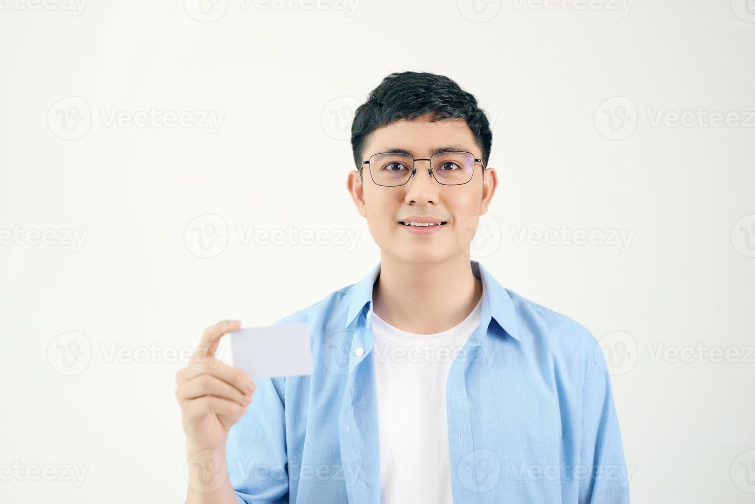 joven asiático mostrando una tarjeta vacía aislada de fondo blanco. foto