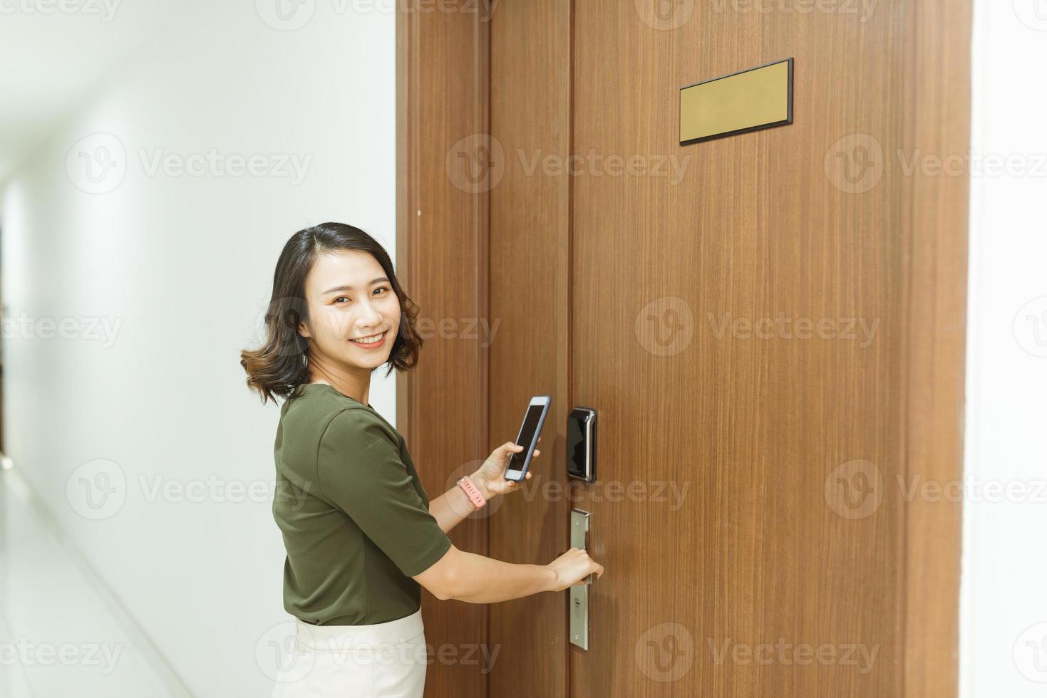 Woman use mobile phone scanning pass code for opening Electronic door lock photo