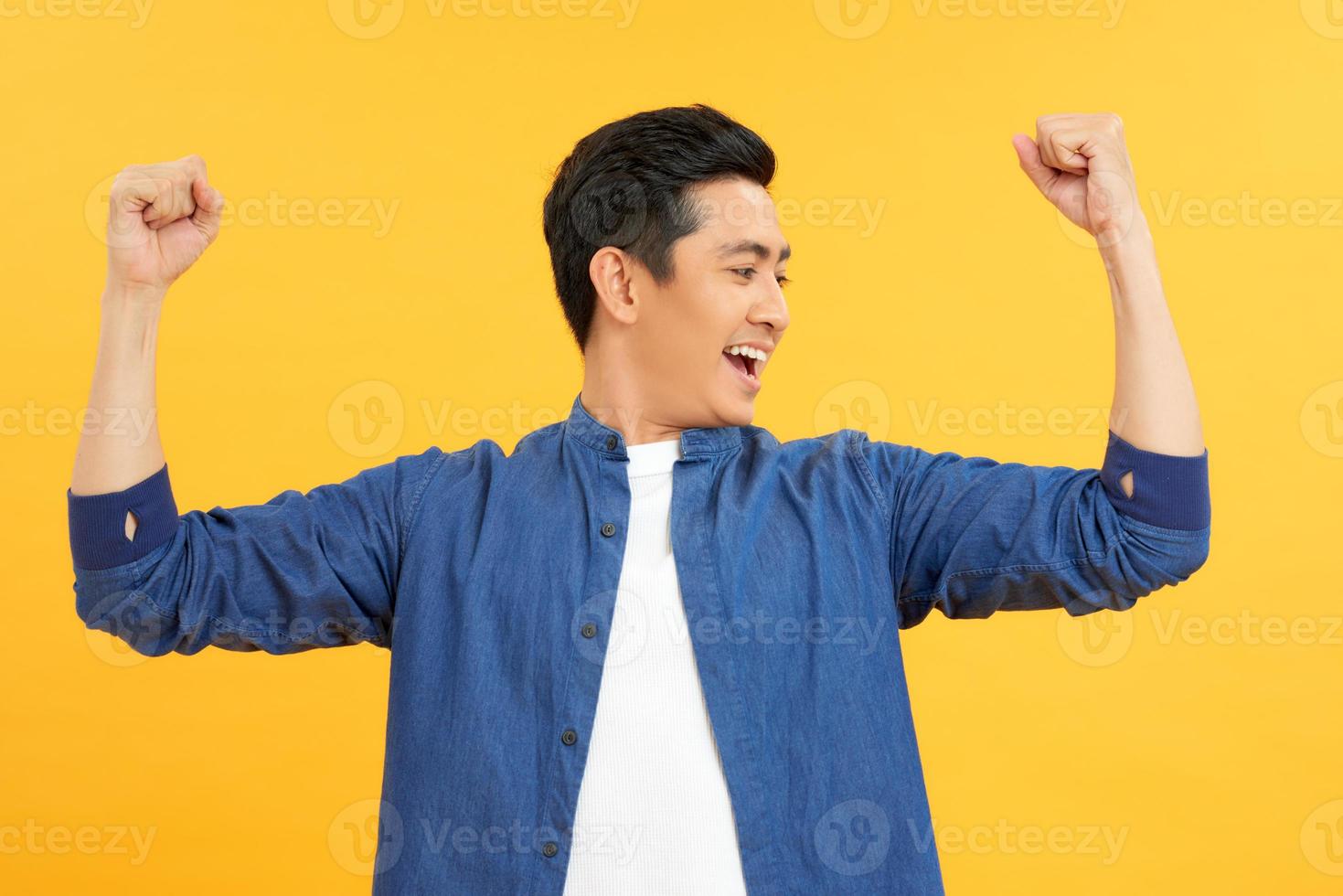 Successful man with arms up - isolated over a yellow background photo