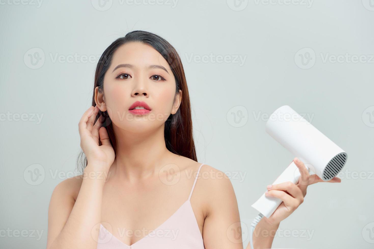 Young girl with hair dryer isolated photo