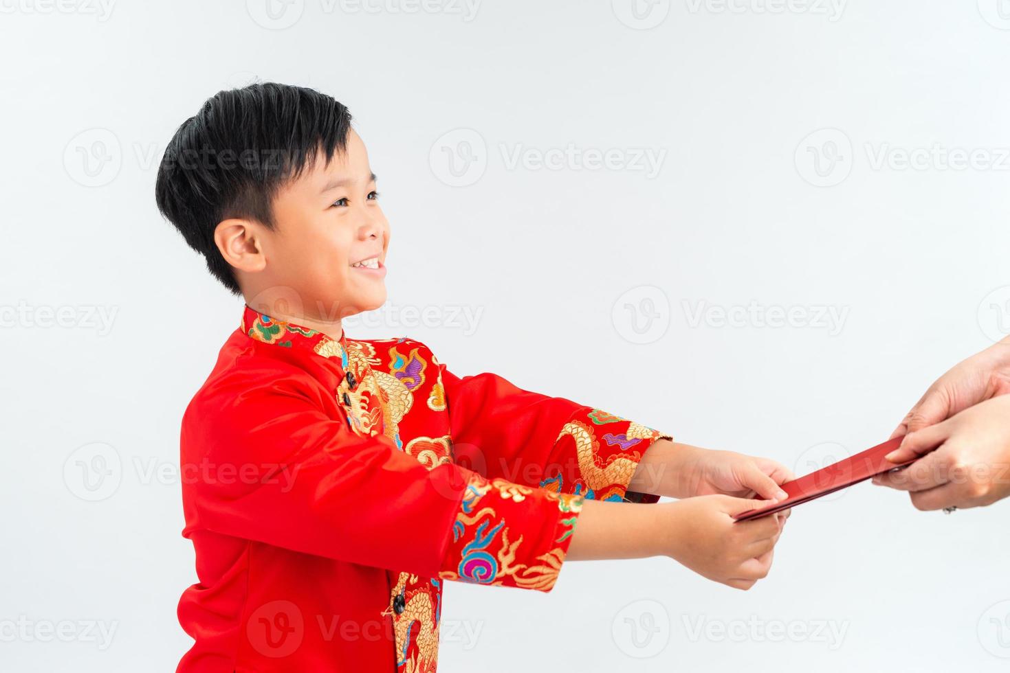 Asian Vietnamese boy receiving red paper packet or monetary from another on lunar New Year festival, with traditional Ao dai isolated on white background. photo
