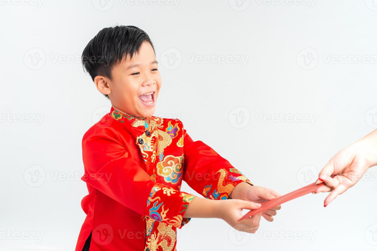 Asian Vietnamese boy receiving red paper packet or monetary from another on lunar New Year festival, with traditional Ao dai isolated on white background. photo