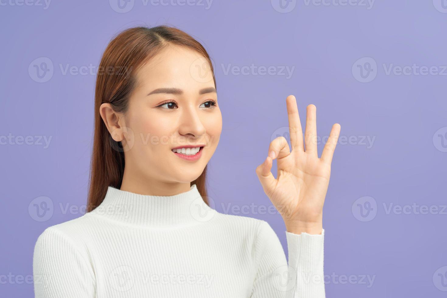 Attractive woman showing ok sign over white background photo