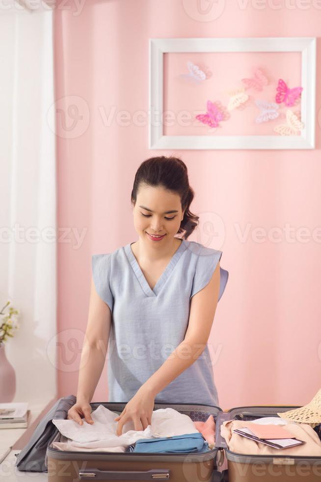 Woman hand packing a luggage for a new journey and travel for a long weekend photo