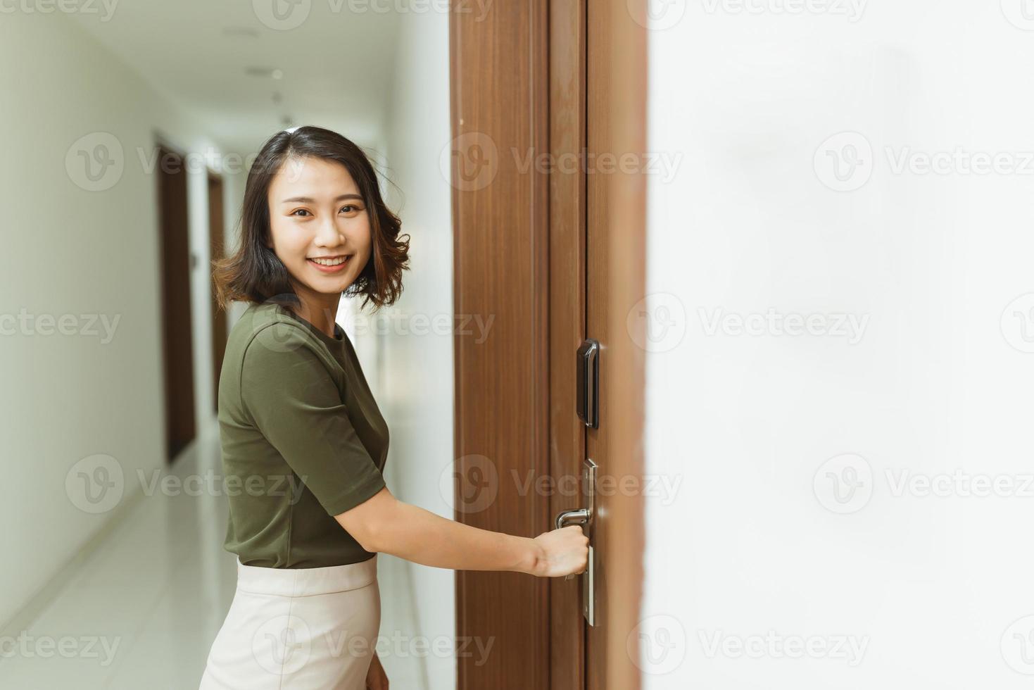 mano de mujer sosteniendo manijas de puerta modernas cerradura electrónica abre la puerta del apartamento foto