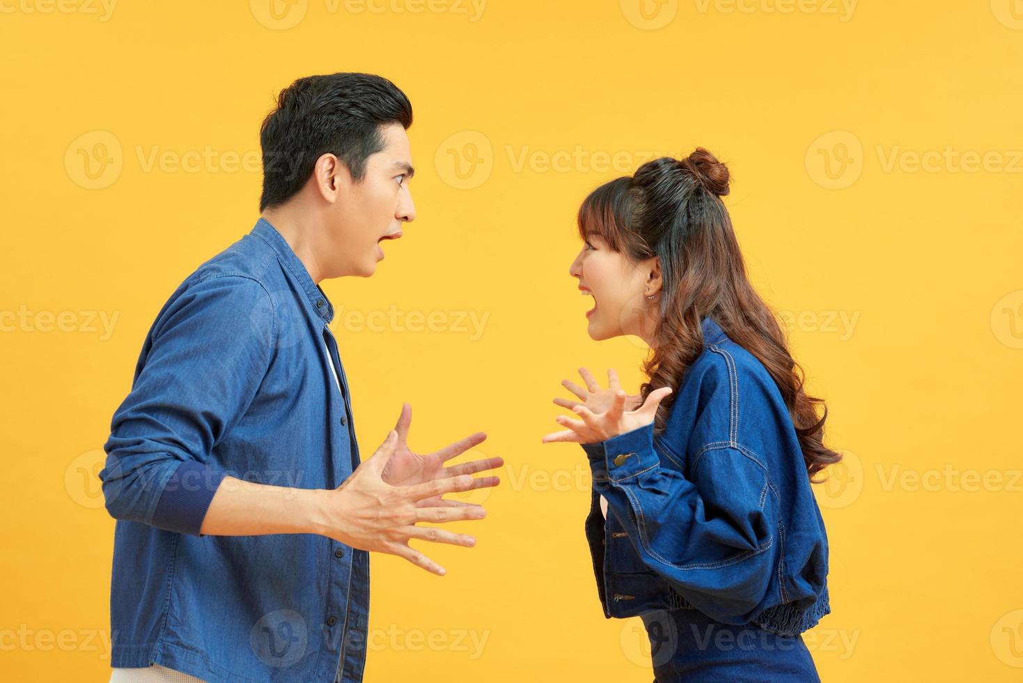 vProfile side view portrait of two attractive angry aggressive nervous people having fight anger blame isolated over vivid shine bright orange background. Negative emotions concept. photo