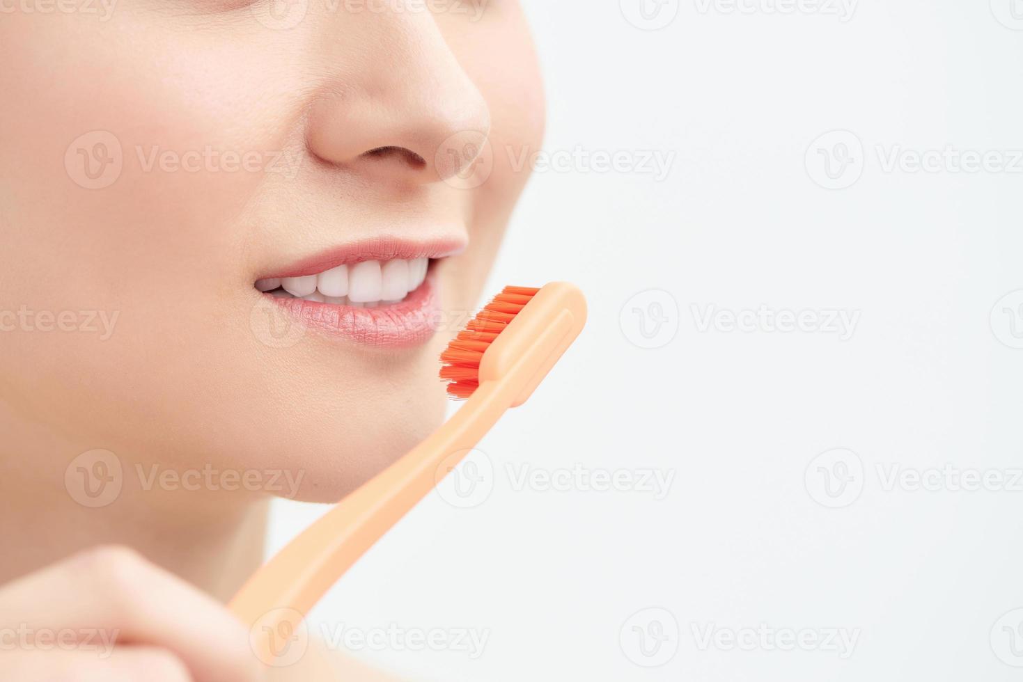 concepto de dentista y ortodoncista. mujer joven limpiando y cepillando los dientes con cepillo de dientes foto