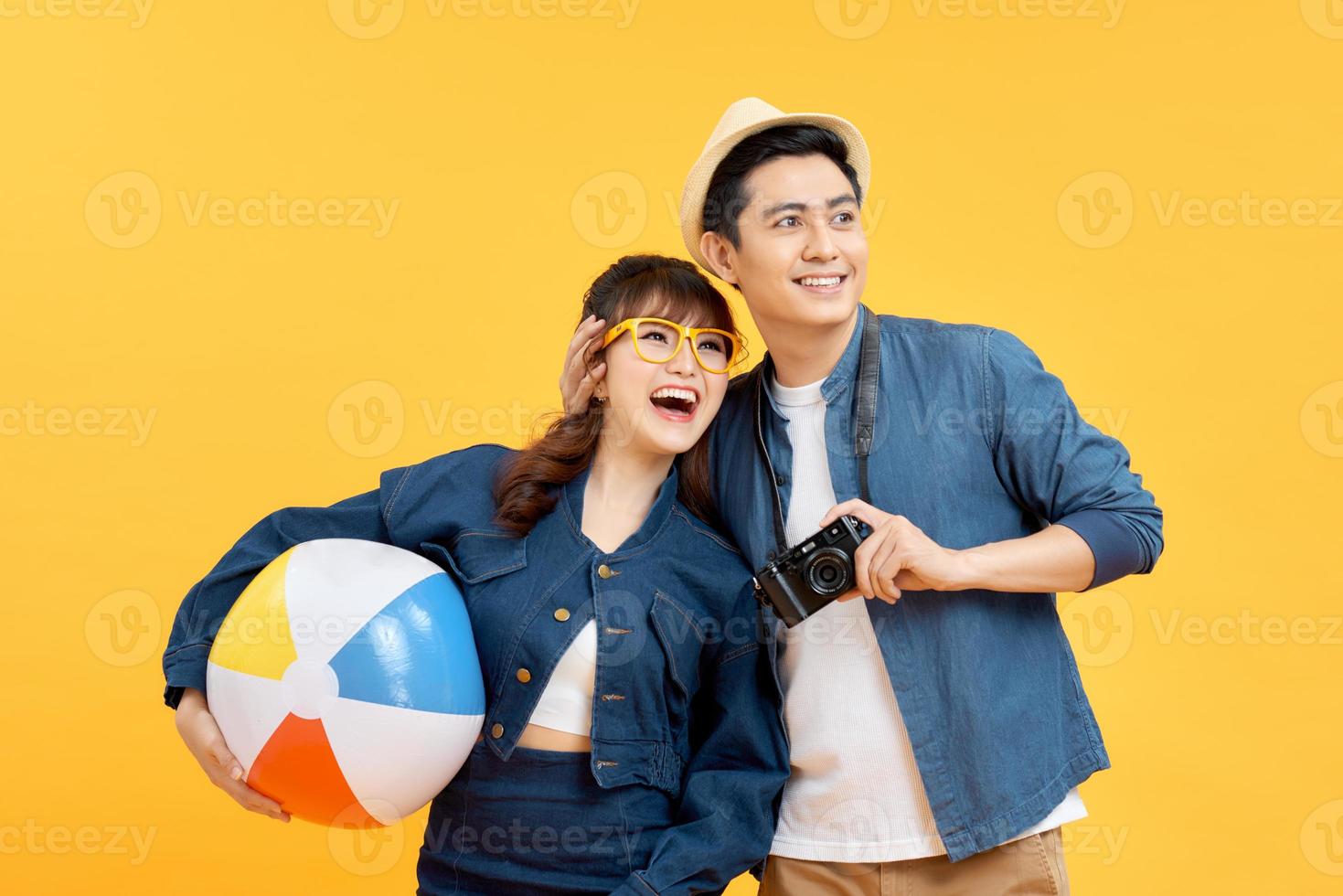 Attractive asian couple in casual outfit with digital camera  go to the beach photo