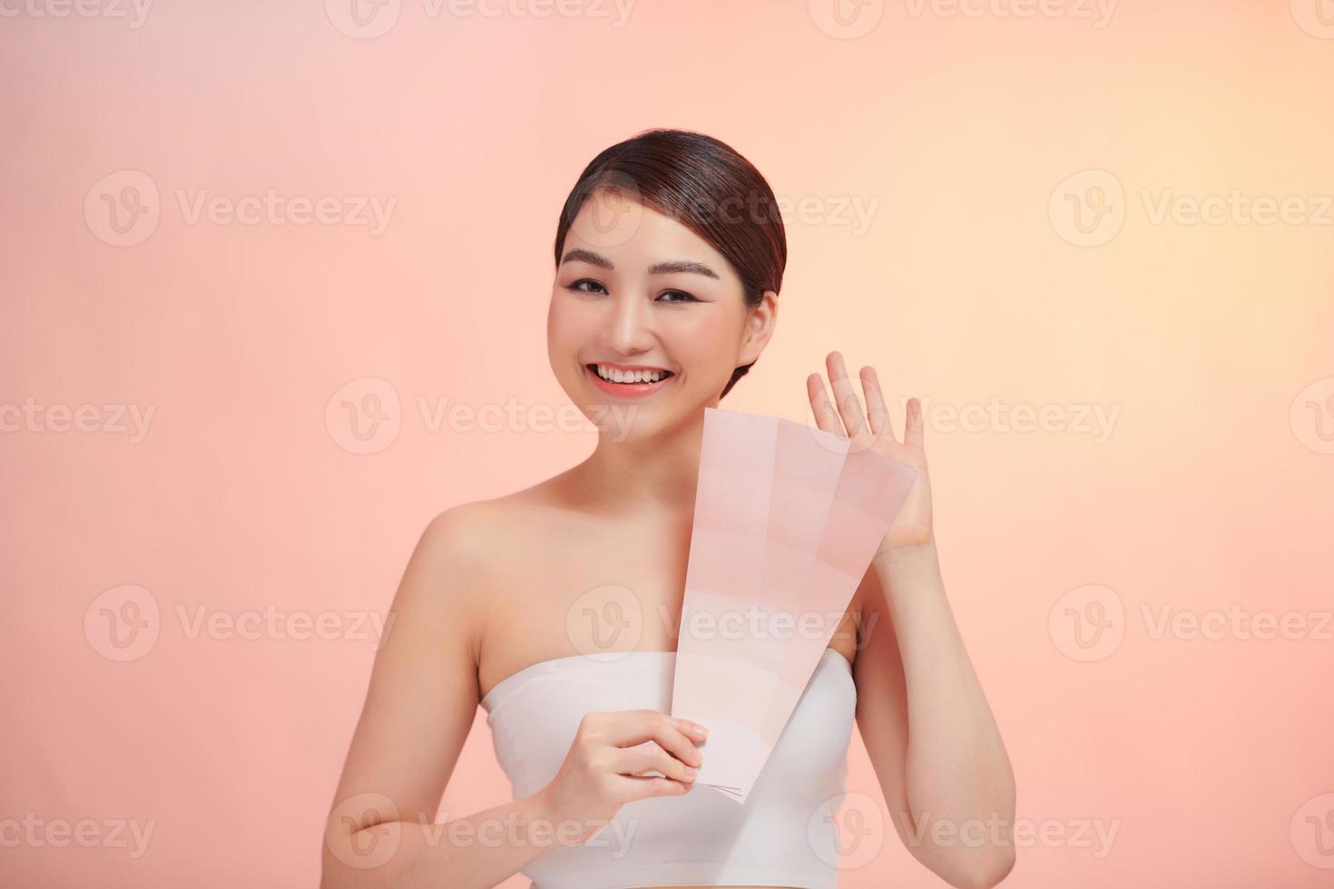 cute woman take skin color scale on the beige background photo