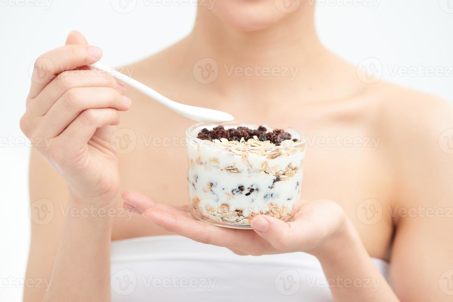 Woman holding yogurt and mixed  raisin with cereal while relaxing at home. dieting concept photo