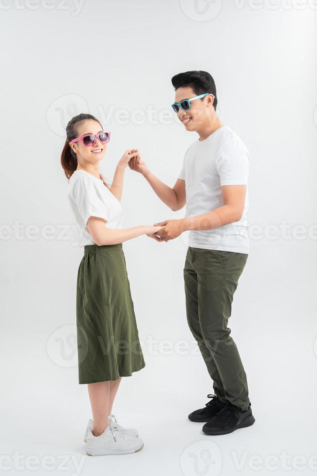 smiling young couple dancing and holding hands, isolated on white photo