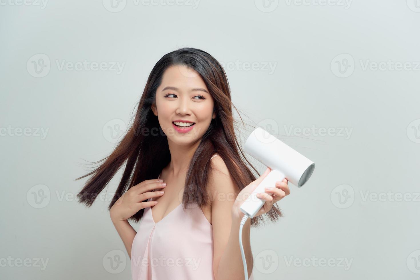 retrato de mujer joven feliz secado con secador foto