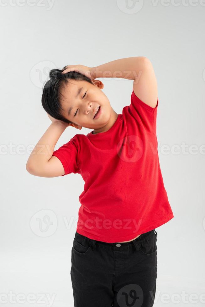 Frustrated Little Asian boy screaming with both hands holding his head isolated on white background. photo