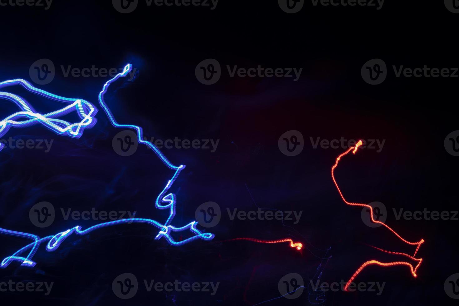 Chaotic lines in dark. Neon glow. Texture of bright lines. photo