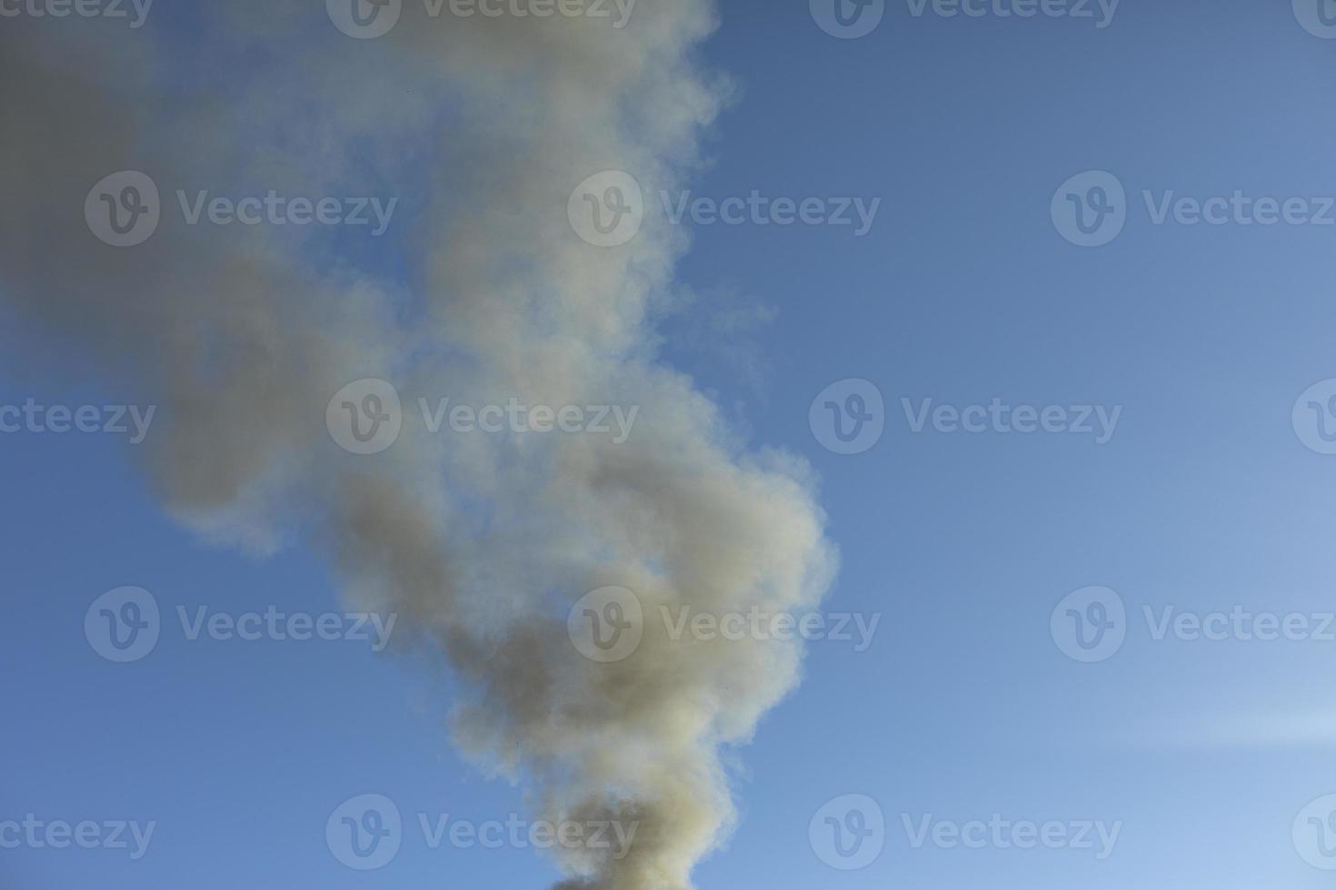 humo y cielo. el humo negro se eleva en el aire. foto