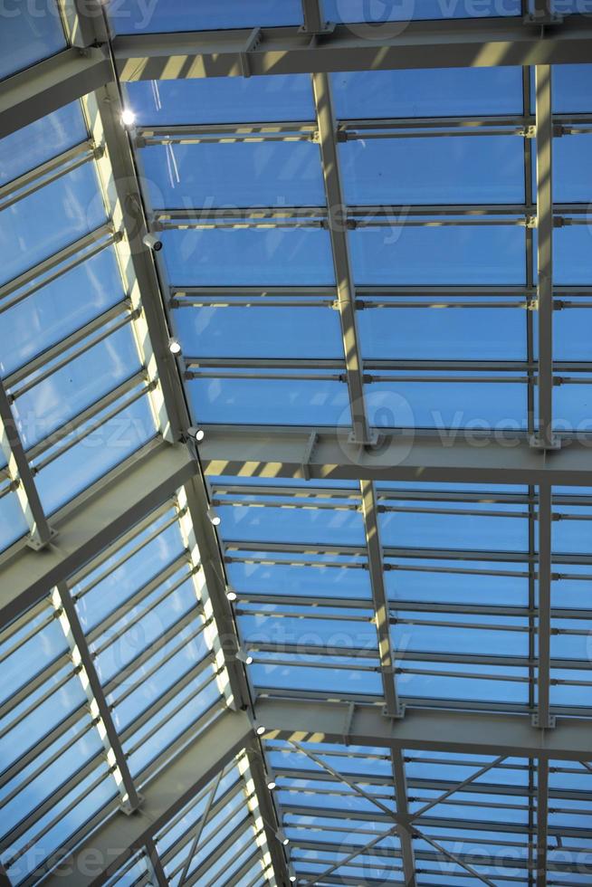 Glass roof in shopping mall. Details of interior in building. Light through glass. Dome in building. photo