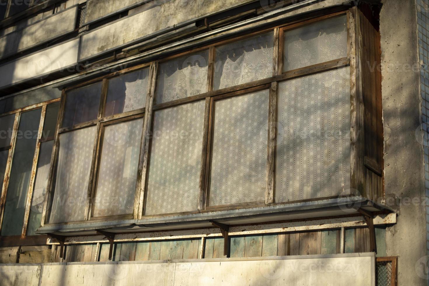 viejo balcón en casa. marcos de ventanas de madera. El edificio está en detalle. foto