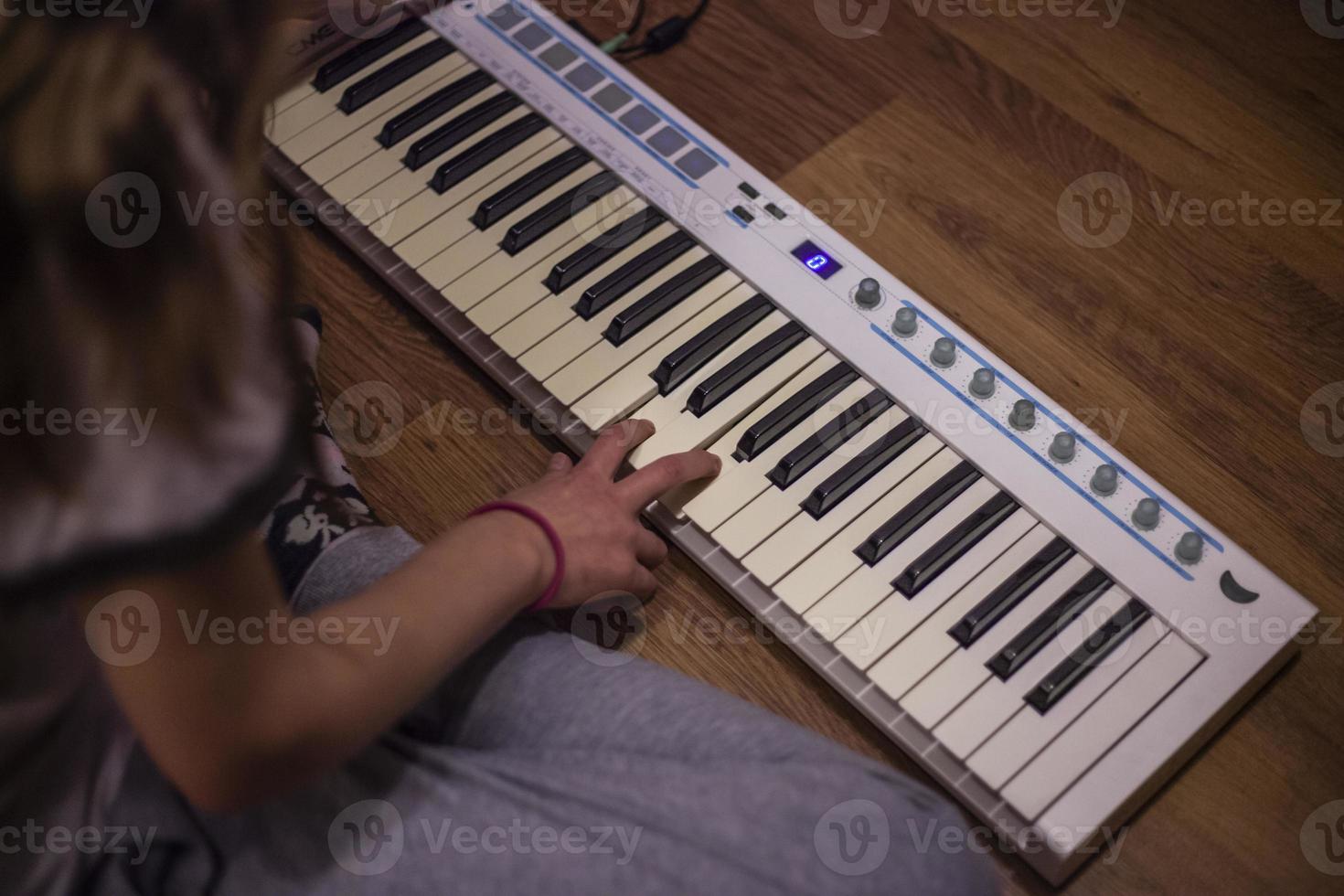 Playing piano. Girls play keys. Synthesizer at home. Hobby music. photo