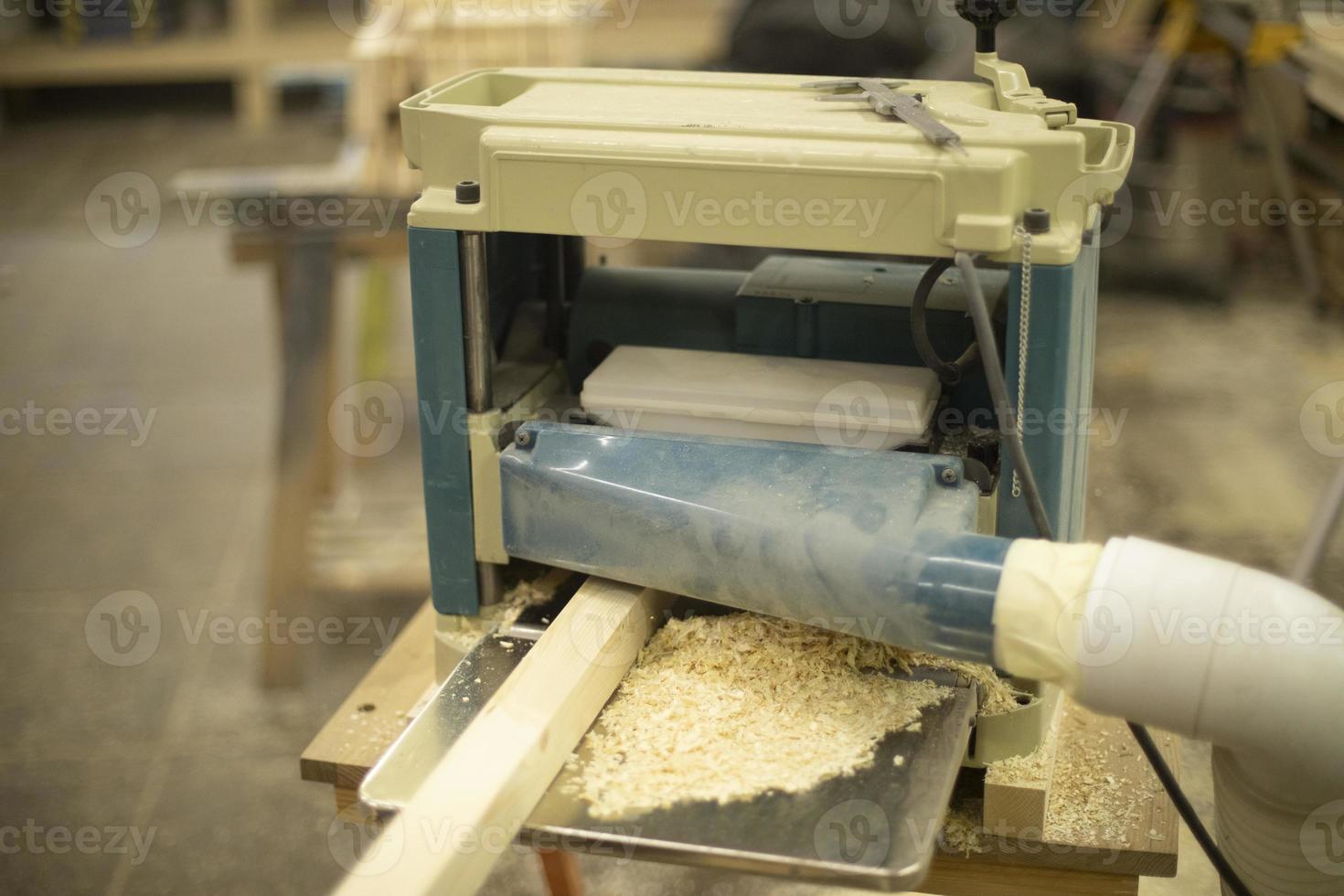 Cutting board in wood workshop. Processing of wood bar. Sawing off layer. photo