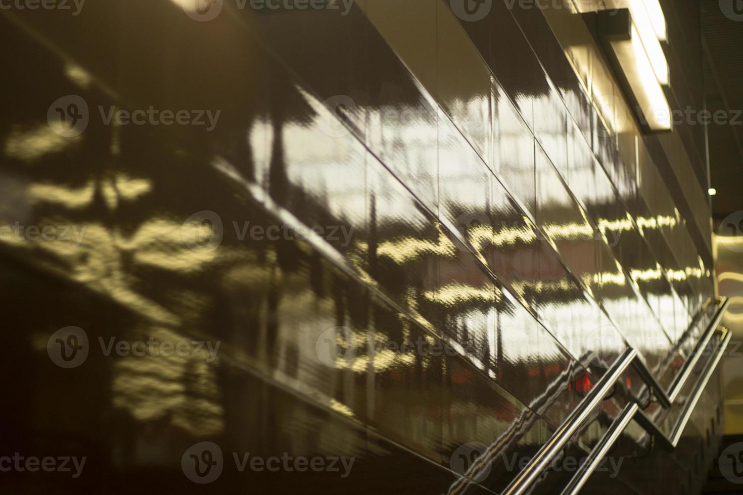 Reflection in wall of light. Handrail for climbing stairs. photo