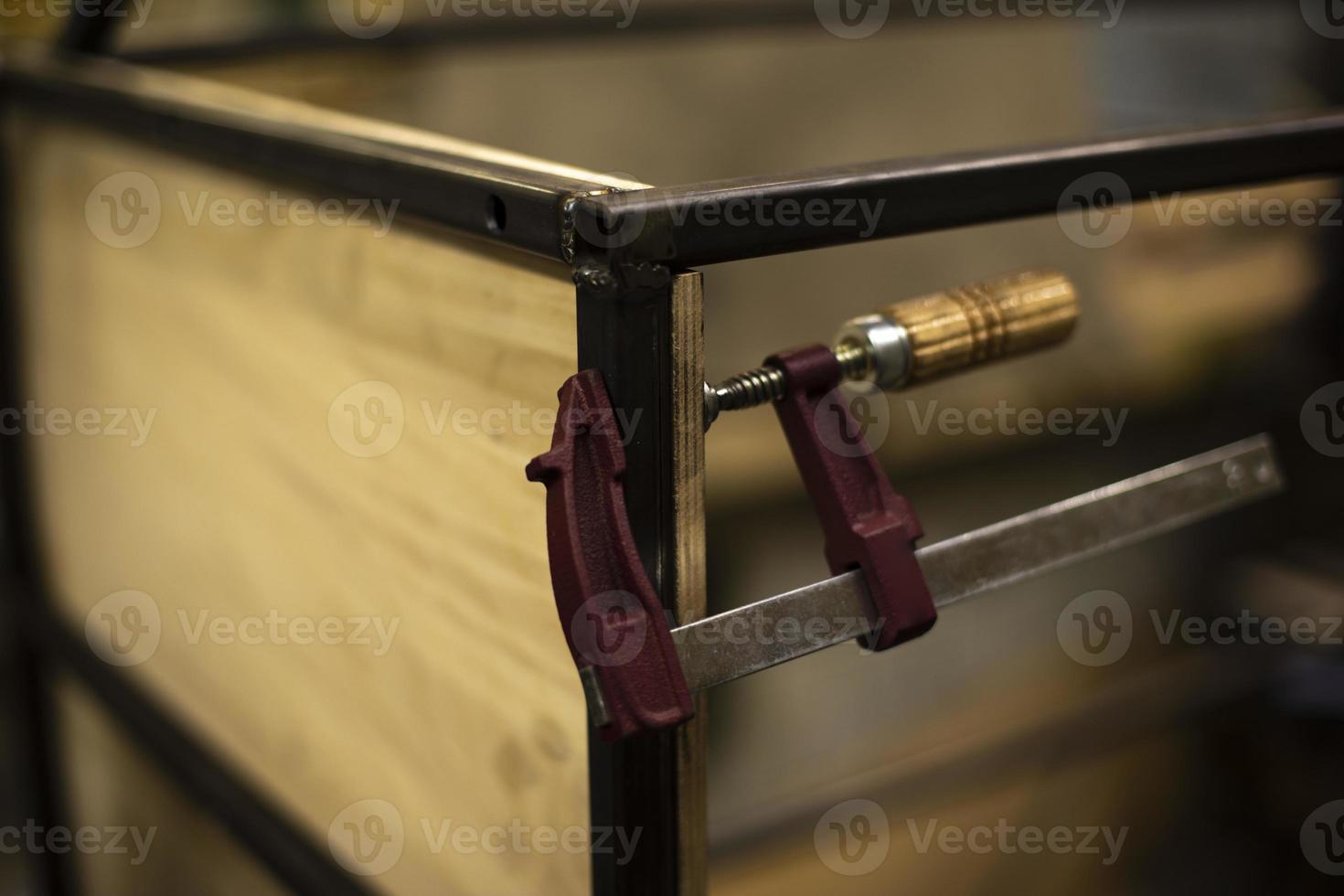 Part holder in carpentry workshop. Board clip. Sturdy fastener to compress layers. photo